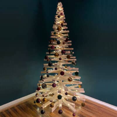 Geschmückter Large Franky Weihnachtsbaum aus Holz mit Lichtern und Weihnachtskugeln, nachhaltige Alternative zum traditionellen Weihnachtsbaum.